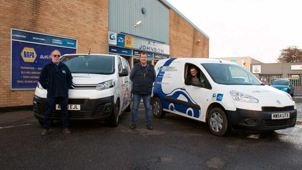 Members of the team stand next to A.T. Johnson delivery vans 
